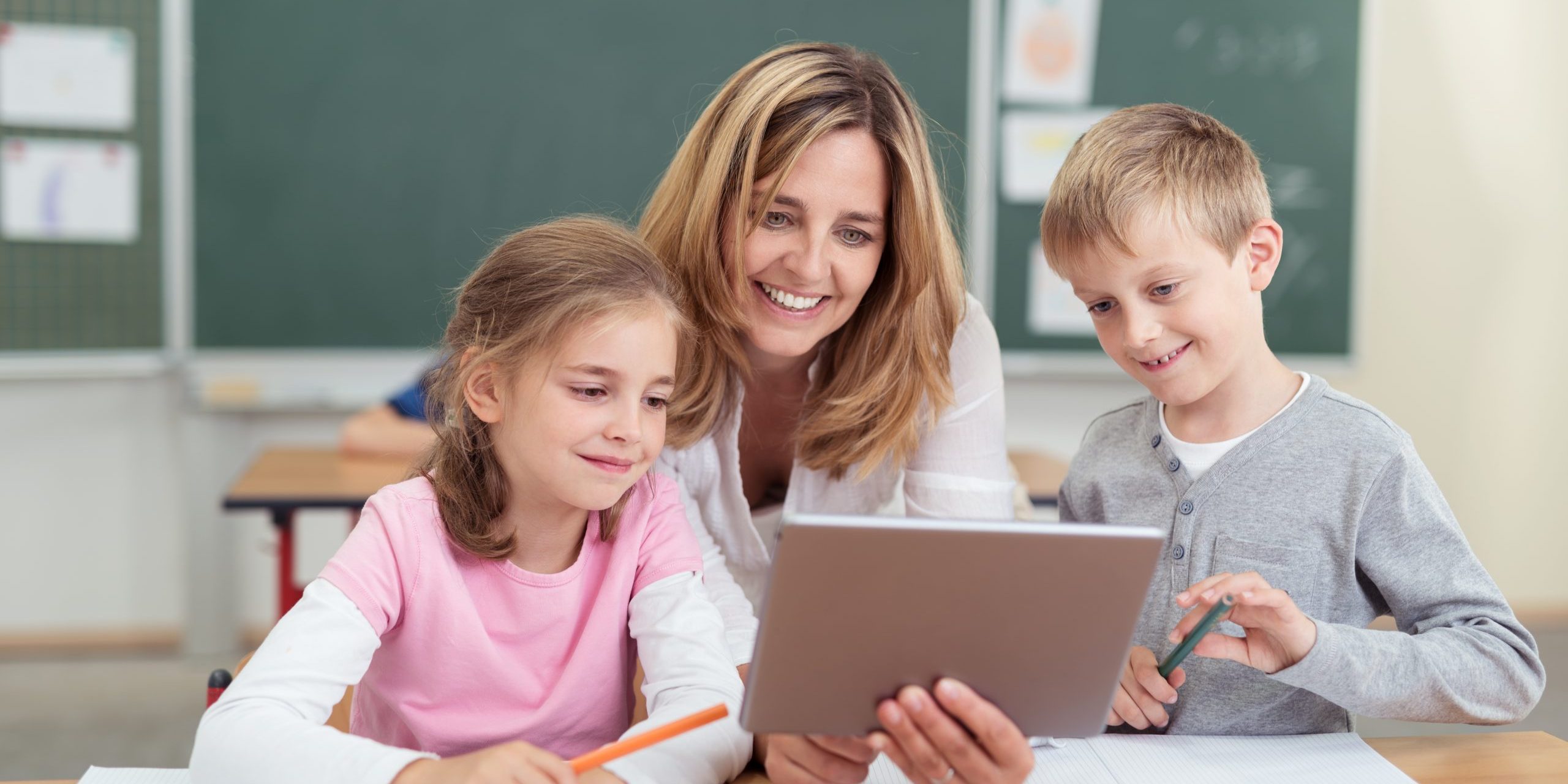 lehrerin zeigt kindern etwas am tablet lehrerin zeigt kindern etwas am tablet